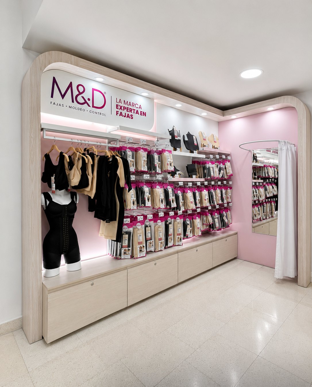 Módulo de Fajas M&D en Locatel Chapinero, en madera clara con arco, letrero de marca y exhibición de producto