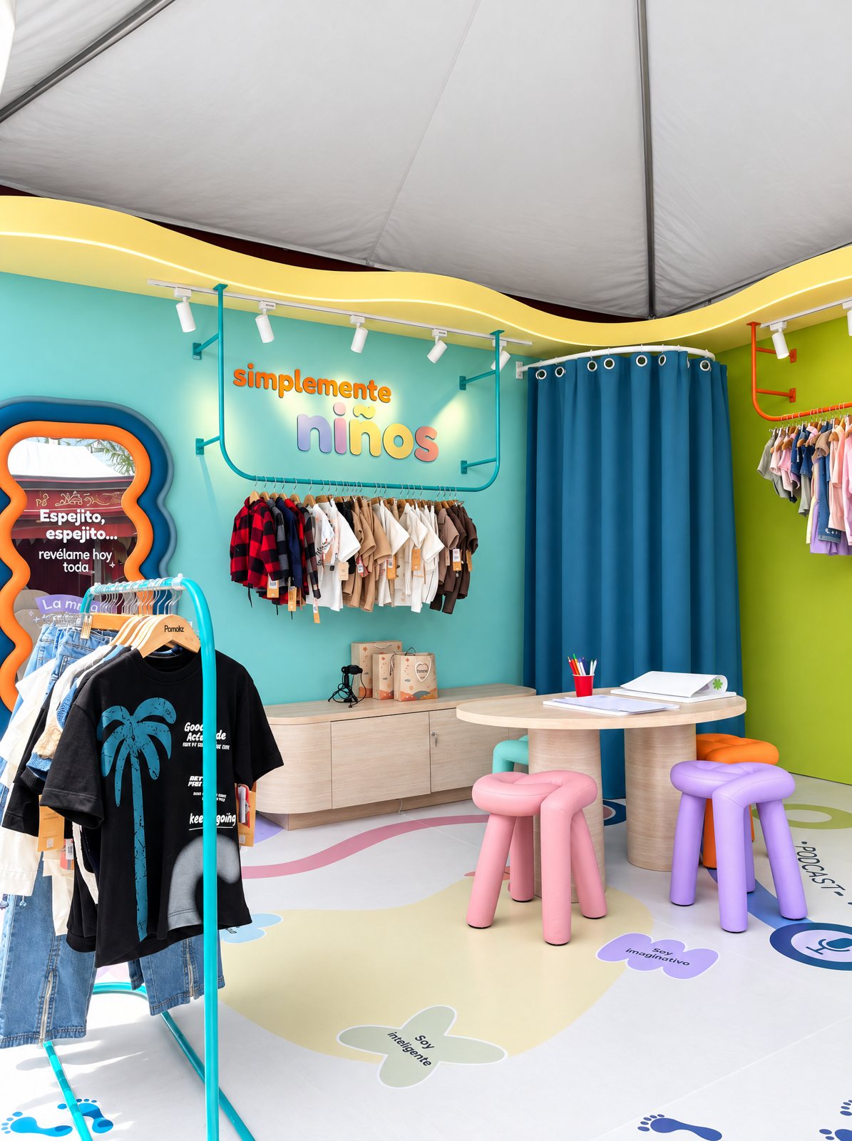 Stand de Pamodiz con perchero, espejo, mesa de dibujo y banquitos de colores